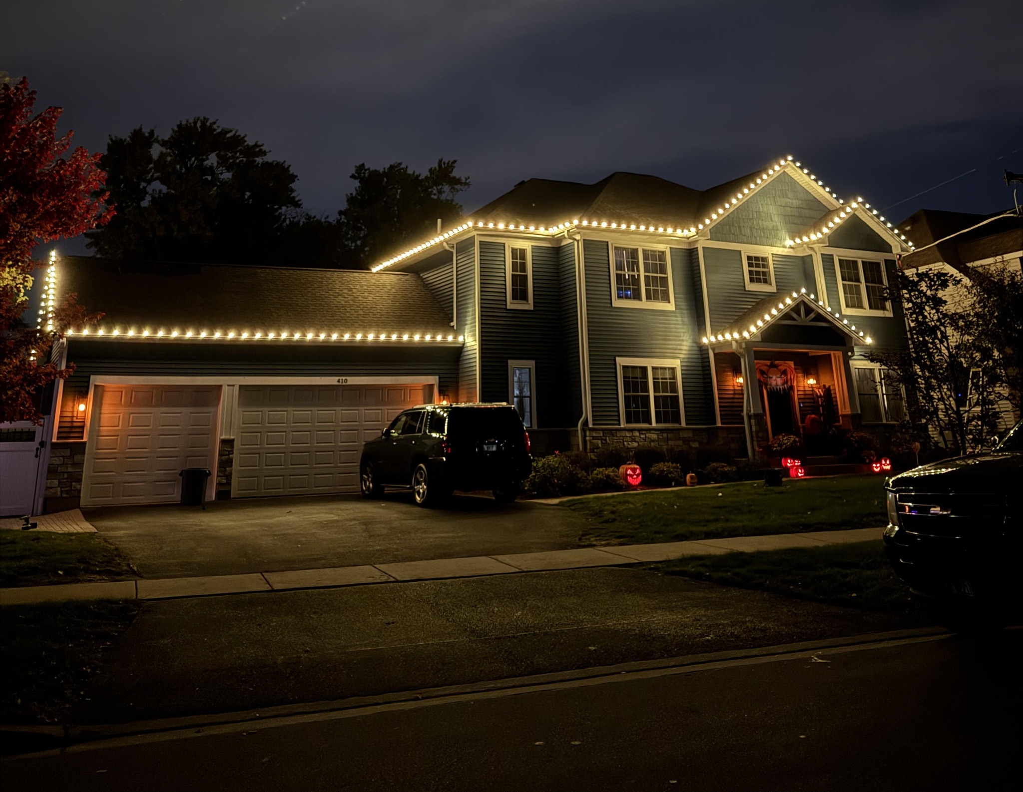 Warm white holiday lights outlining a home's roofline at night